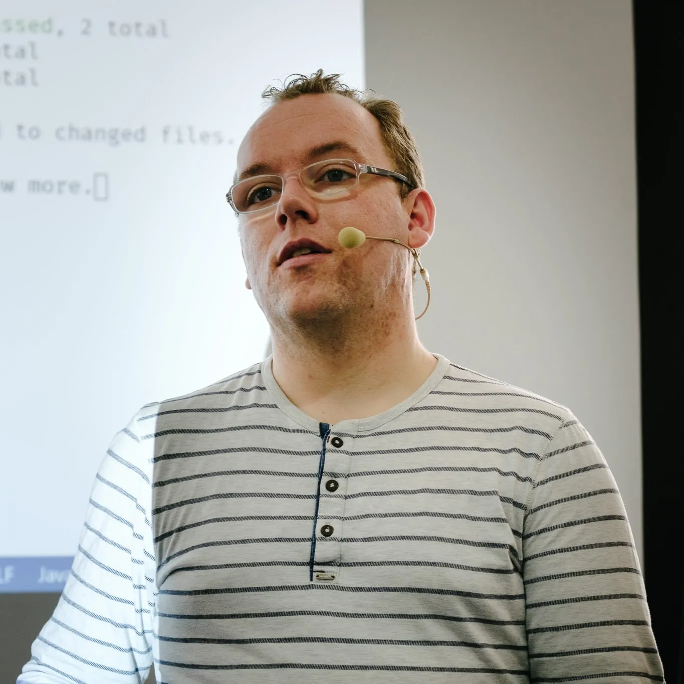 Elmar Burke in front of a projector screen at a conference